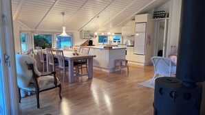 A spacious kitchen with a central island, wooden dining table, and chairs. - Super cozy holiday home in Marielyst (Væggerløse)