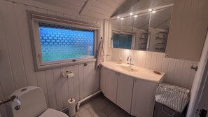 A bathroom with a toilet, sink, mirror, and window. - Super cozy holiday home in Marielyst (Væggerløse)