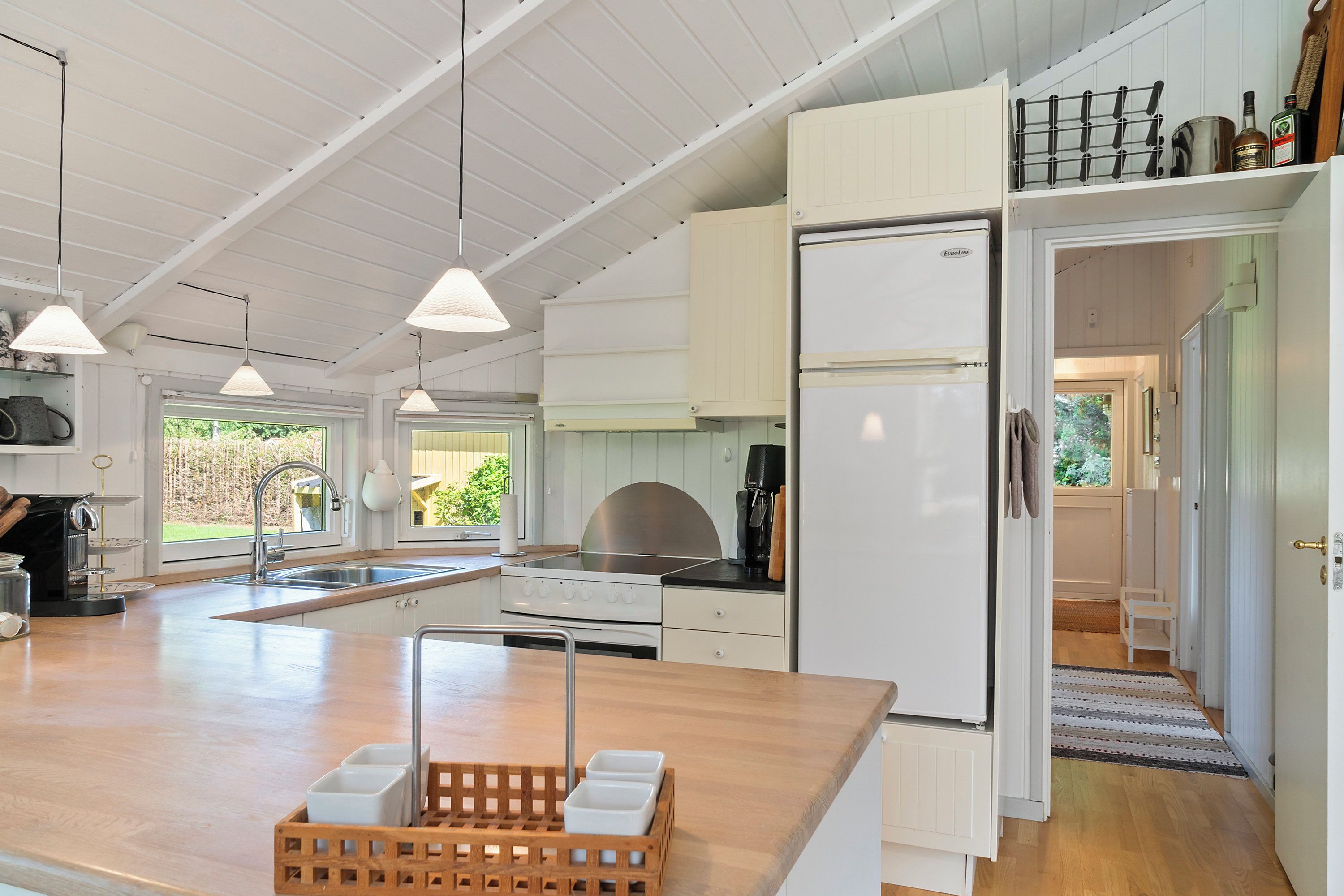 A modern kitchen with a central island, a built-in oven, and a refrigerator.