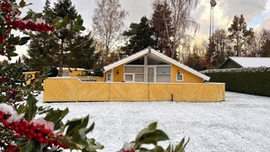 A yellow building with a pitched roof, large windows, and a fenced yard. - Super cozy holiday home in Marielyst (Væggerløse)
