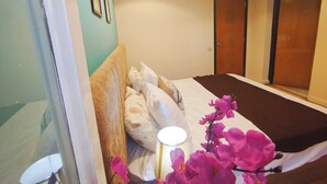 A bedroom with a bed, pillows, a bedside table, and a lamp. - Garden City Apartment in Downtown Cairo (Cairo)