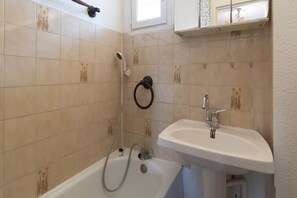 A bathroom with a bathtub, a shower, and a sink. - Coastal Comfort in Agde (Agde)