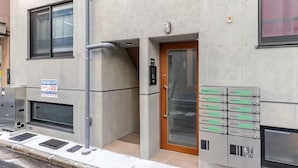 A building entrance with a metal door, a window, and a sign. - CROWN Asakusabashi (Tokyo)