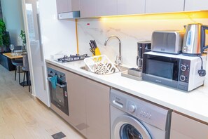Cuina moderna amb rentaplats integrat, microones i cafetera.