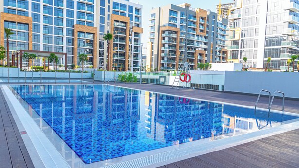 A rooftop swimming pool with a clear view of surrounding high-rise buildings. - Bloomfields STU View Azizi Riviera (Dubai)