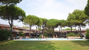 Une piscine entourée d’arbres et de bâtiments.