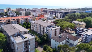 A residential area with multi-story buildings, some with balconies, and a beach in the background. - Large house by the beach - Beahost (Bibione)