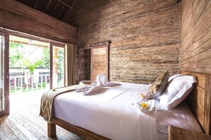 Une pièce en bois avec un lit, une fenêtre et une porte.