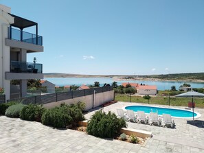 Un edificio moderno con piscina y zona de estar al aire libre.