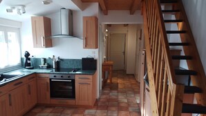 A kitchen with wooden cabinets, a stove, and a coffee maker.