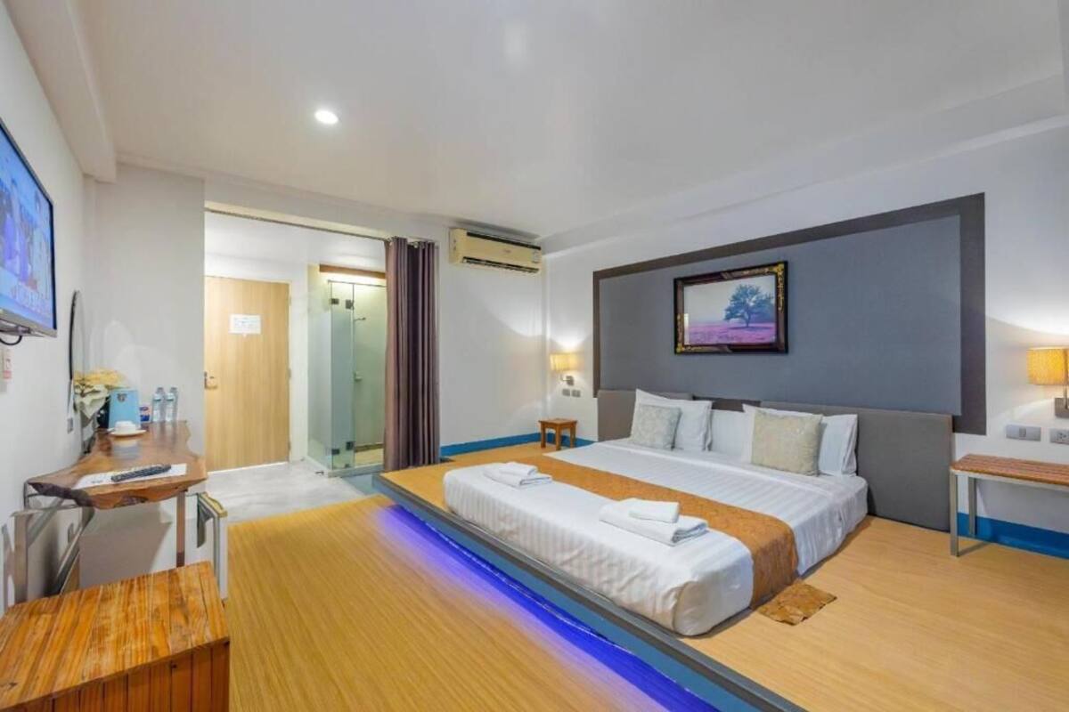 Une chambre d’hôtel comprenant un lit, une table de chevet, un bureau et une petite table avec une chaise.
