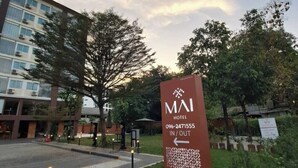 Un letrero de hotel con el nombre 'MAI HOTEL' y un número de teléfono.