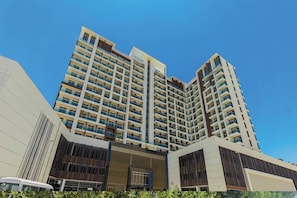 A high-rise building with multiple balconies and a modern architectural design.
