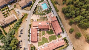 An aerial view of a residential area with multiple buildings, a swimming pool, and a landscaped garden.