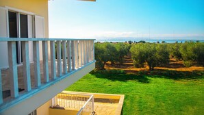 A balcony with a view of a green lawn and olive trees. - The FAROS Estate Angelochori - spacious villa with pool to make you feel at home (Angelochori)