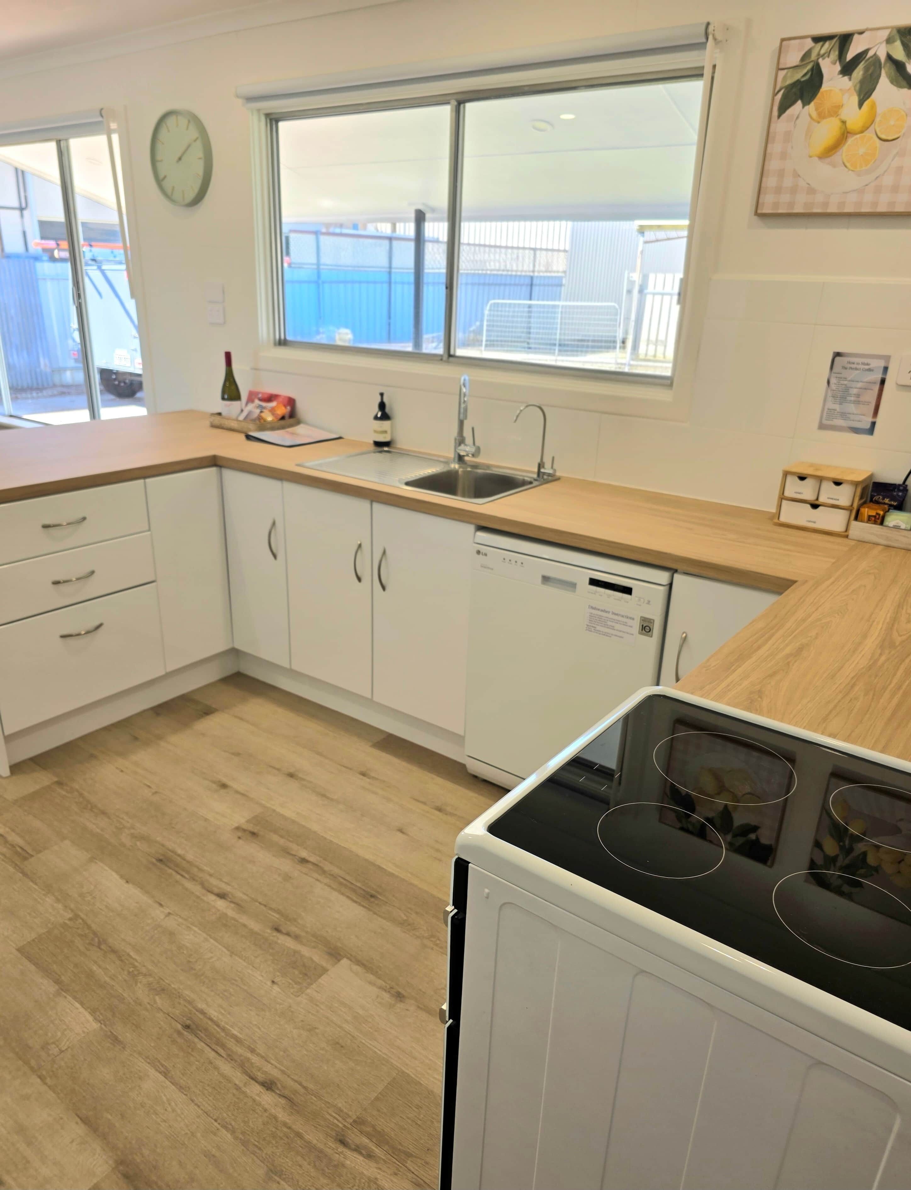 Een moderne keuken met witte kastjes, een roestvrijstalen spoelbak en een inbouwvaatwasser.
