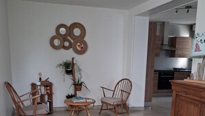 A living room with two wooden chairs, a small table, and a cabinet.