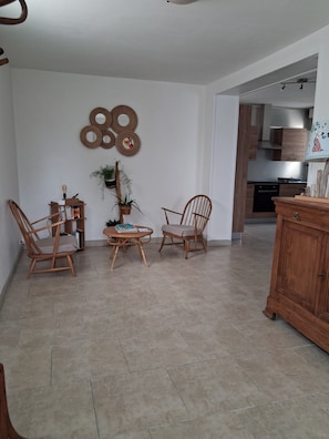 A living room with two wooden chairs, a small table, and a cabinet.