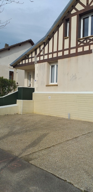 A two-story building with a gabled roof and a small porch.