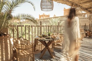 A patio with wicker furniture, a round table, and a view of a historic building in the background.