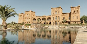 A large, traditional building with arched windows and a courtyard with a reflecting pool.