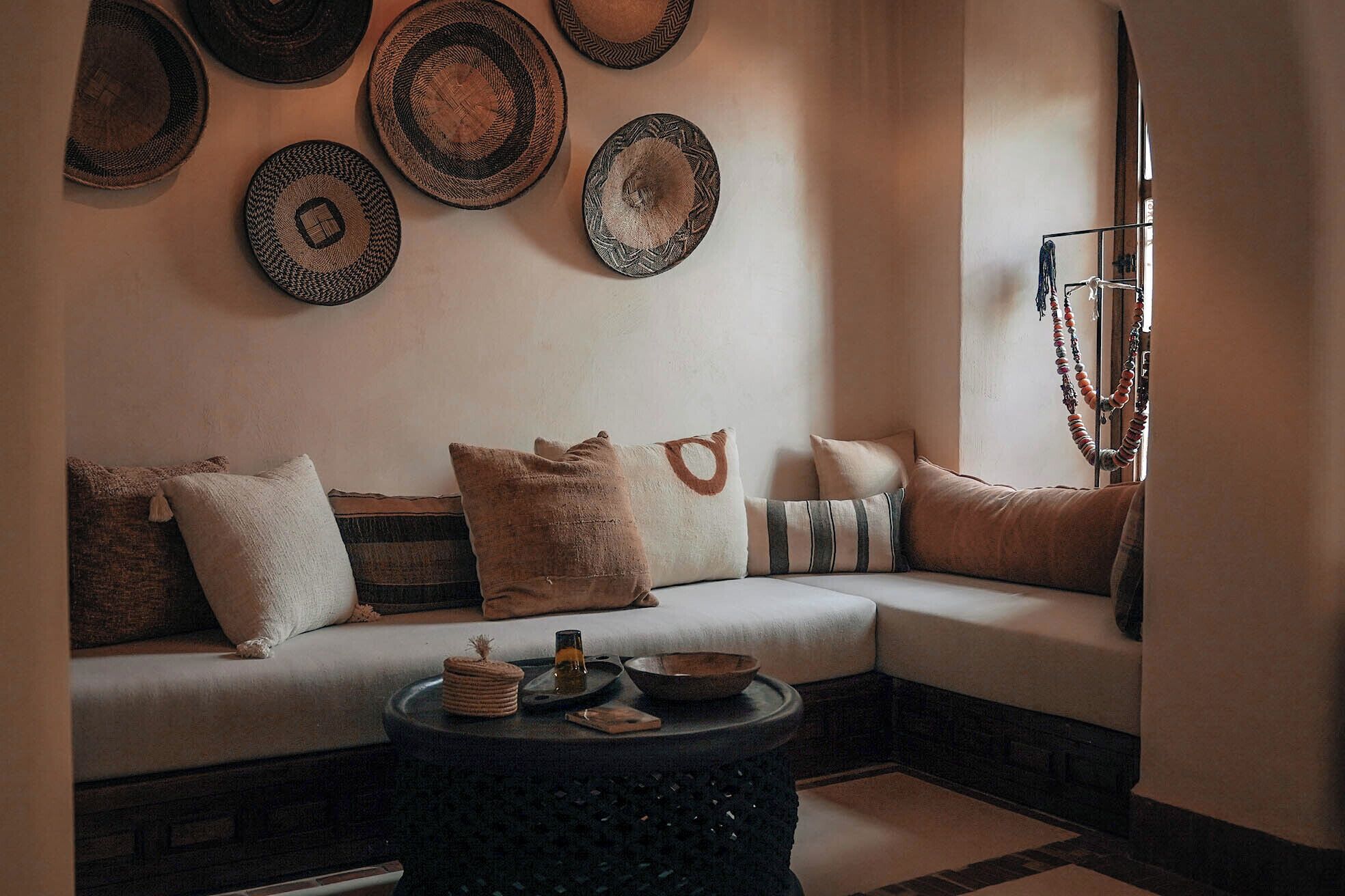 A cozy living room with a sectional sofa, a round coffee table, and decorative plates on the wall.
