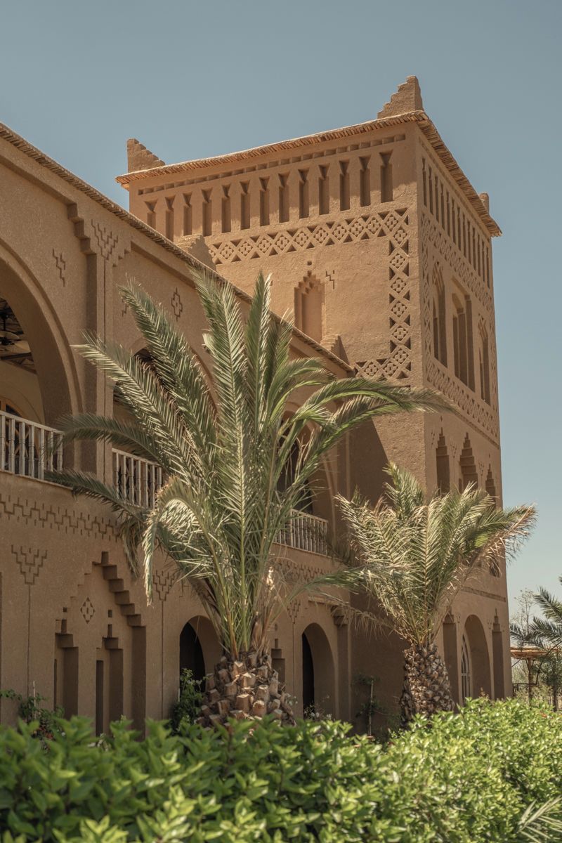 Een gebouw met een traditionele architectuur, herkenbaar aan boogvormige deuropeningen en ingewikkelde geometrische patronen op de gevel.