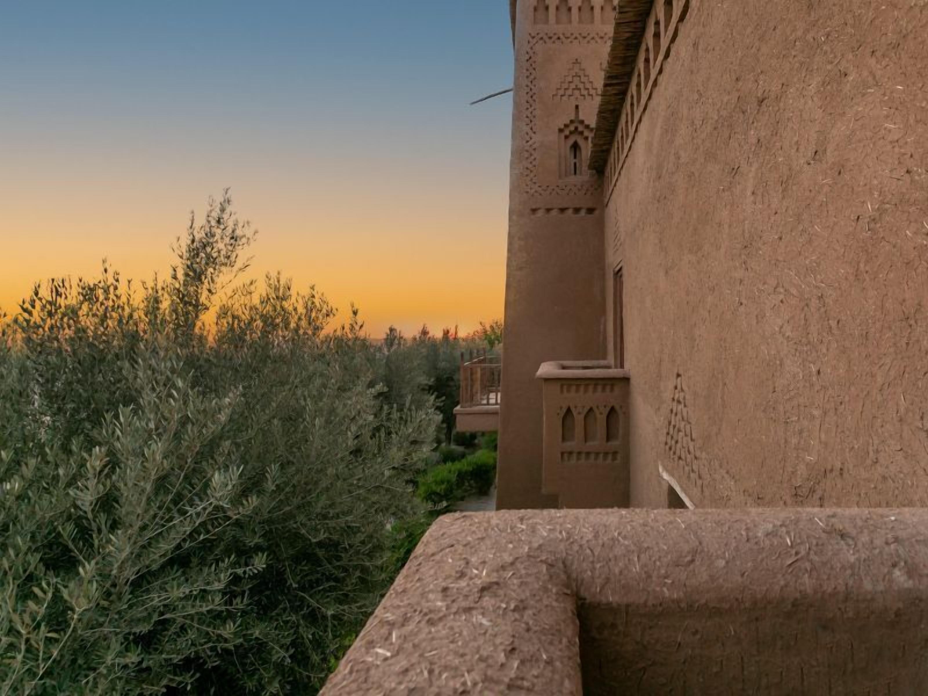 A building with a traditional architectural style, featuring a tower with intricate carvings and a balcony.