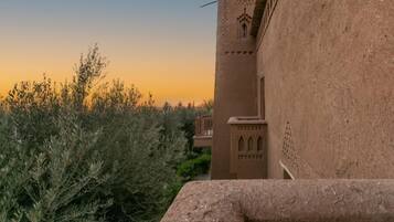 A building with a traditional architectural style, featuring a tower with intricate carvings and a balcony.