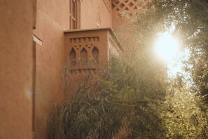 A building with a traditional architectural style, featuring a window with a pointed arch and a decorative wooden frame.