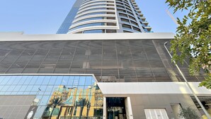 Ein modernes Hochhaus mit geschwungener Fassade, großen Glasfenstern und einem markanten Eingangsbereich.