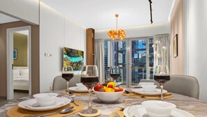 A modern dining room with a marble table, wine glasses, and a fruit bowl.