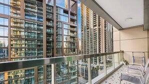 A high-rise residential building with multiple balconies, large windows, and a terrazzo floor.
