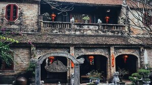 A traditional building with a balcony, arched doorways, and hanging lanterns. - Noibai Sunflower Hotel (Hanoi)