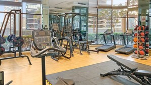A modern gym with cardio machines, weightlifting equipment, and a variety of exercise balls.