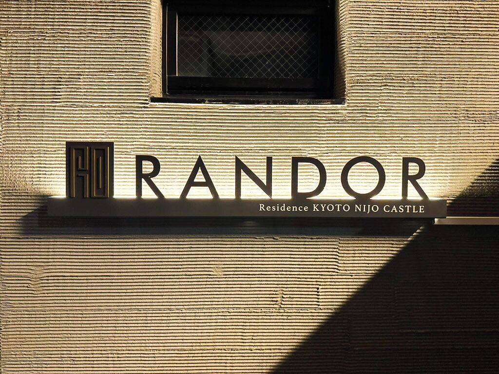 Een bord met de naam 'RANDOR' en de tekst 'Residence KYOTO NIJO CASTLE' op een structuurrijke muur.