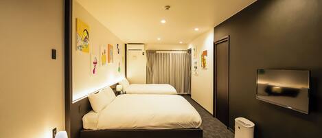 Una habitación de hotel moderna con una cama grande, mesitas de noche, un televisor y obras de arte en las paredes.