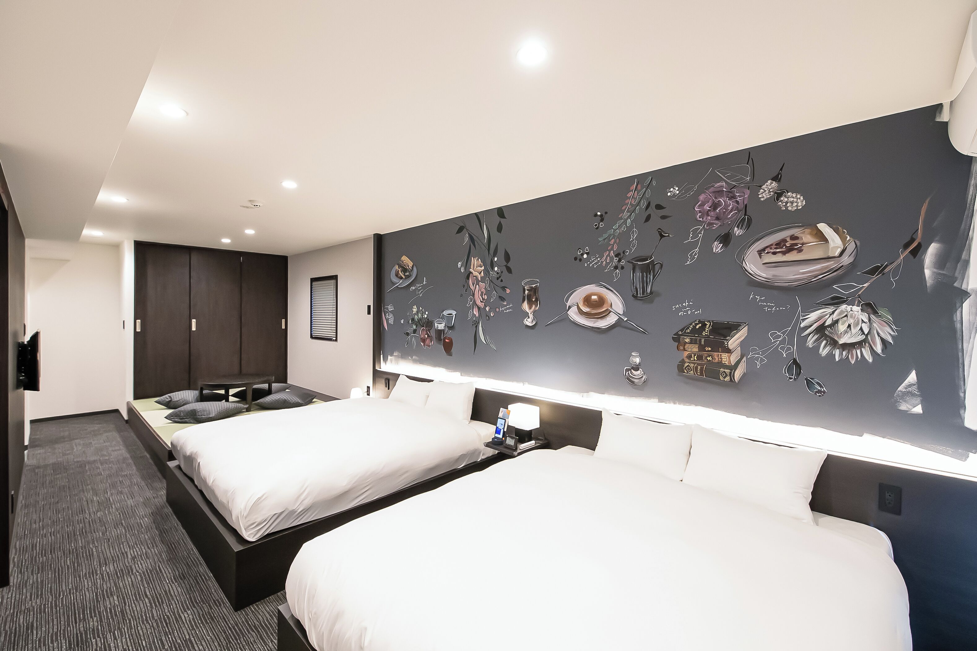Una habitación de hotel moderna con dos camas, un mural grande en la pared y un televisor de pantalla plana.