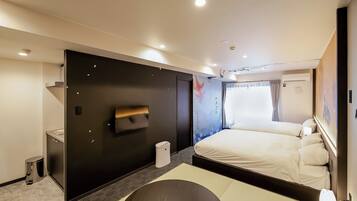 A modern hotel room with a large bed, a flat-screen TV mounted on the wall, a small bedside table, and a window with curtains.