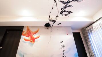 A room with a large wall mural featuring a koi fish and calligraphy.