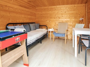 A compact room with a bed, a small table, a chair, and a ping pong table. - 4 Star Holiday Home in Vaeggerlose (Vaeggerlose)