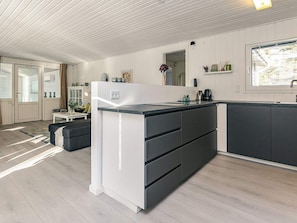 Une cuisine moderne dotée d’un îlot central, de meubles blancs et d’une fenêtre offrant une belle vue.