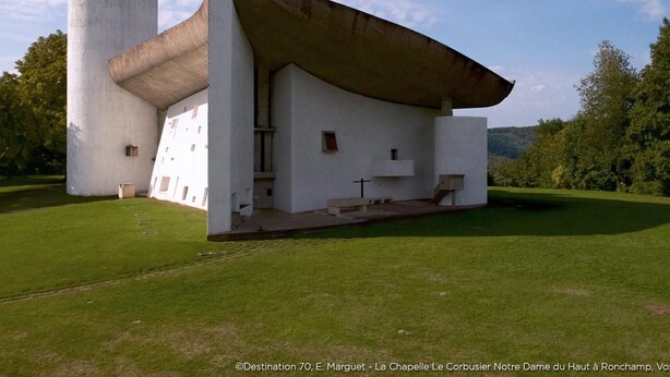 A modern chapel with a unique architectural design, featuring a large white building and a cylindrical tower.