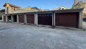 A row of closed garages with a gravel driveway in front. - Bright T2 with garage and WiFi in Aix-les-Bains (Aix-les-Bains)