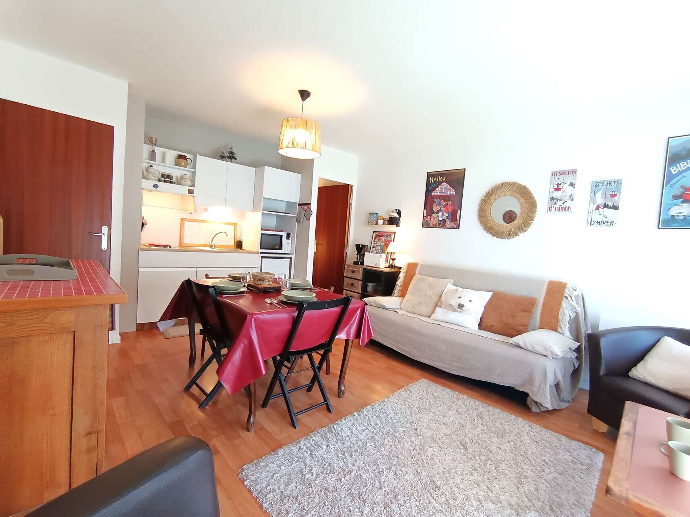 Un espace de vie compact comprenant un coin repas, une kitchenette et un coin salon.