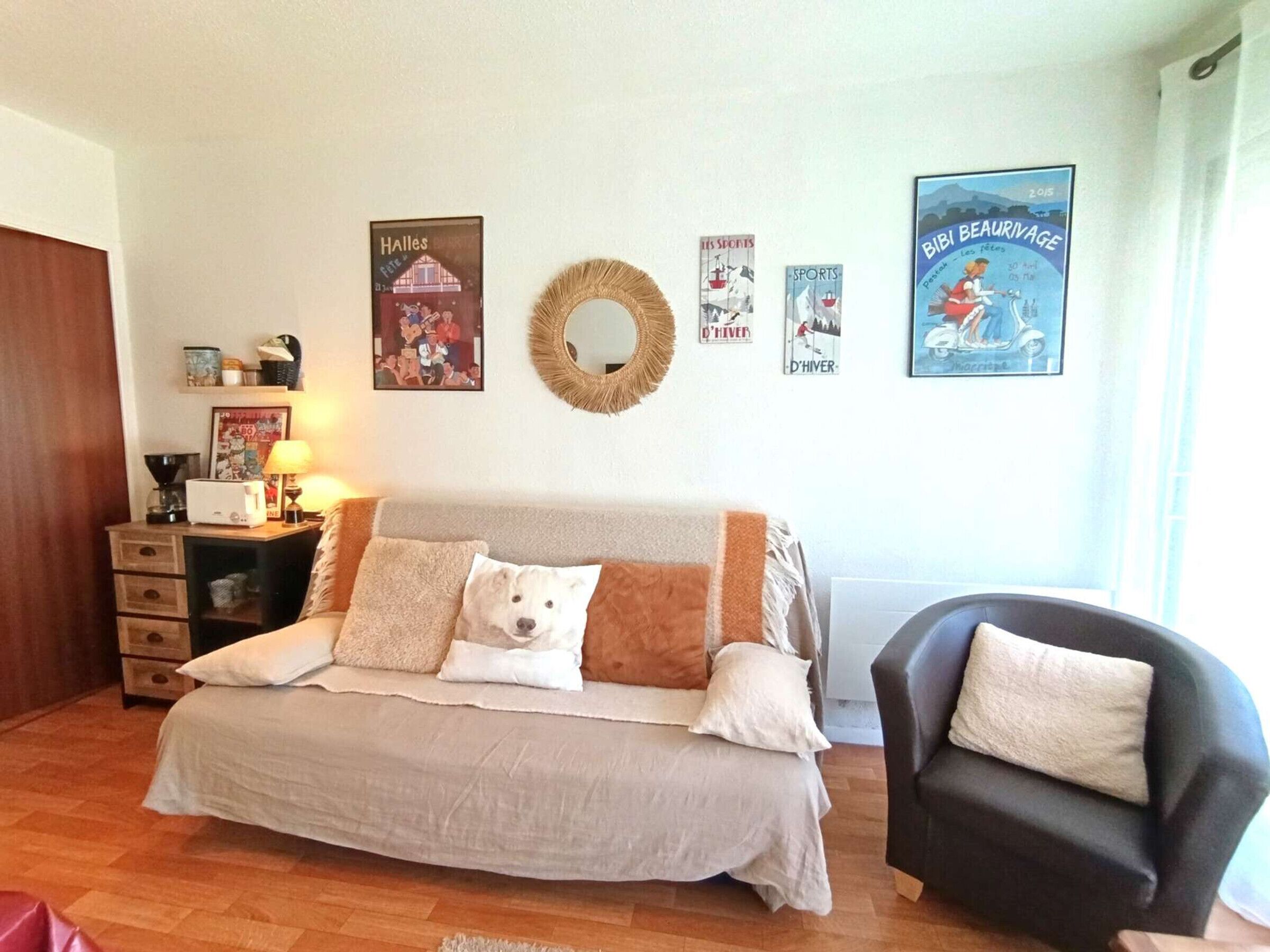 Une chambre à coucher comprenant un lit, une chaise, une commode et un mur décoré de posters sur le thème du sport.
