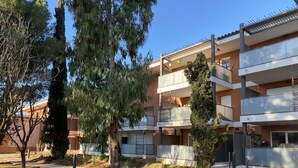 A multi-story residential building with balconies, a grassy area, and trees. - T2 Apartment with large terrace and parking (Balaruc-les-Bains)