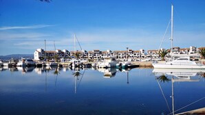 A marina with boats docked, a clear sky, and buildings in the background. - Charming T2 - 4 people - Terrace with port view (Le Barcarès)