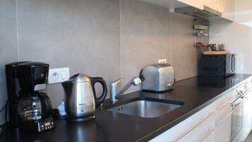 Een microgolfoven, een oven, een kookplaat, een vaatwasser