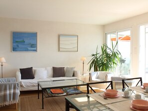 Relax in this stylish living room with a sofa, coffee table, and dining area, offering a view of the outdoors.